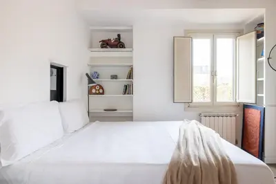 a white bedroom with a large bed and a window at Pantheon Apartment with Terrace in Rome