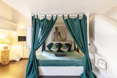 a bedroom with a bed with green curtains at Navona Dream Flat in Rome