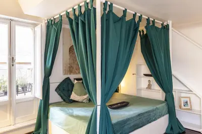 a bedroom with a bed with green curtains at Navona Dream Flat in Rome