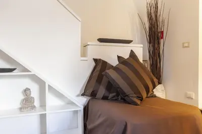 a room with a bed with pillows and a staircase at Navona Dream Flat in Rome