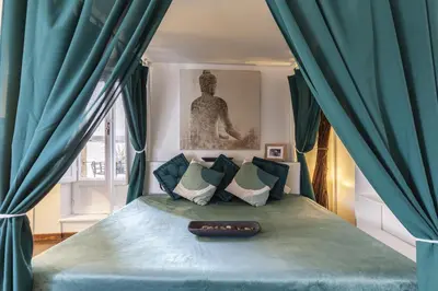 a bedroom with a bed with blue drapes at Navona Dream Flat in Rome