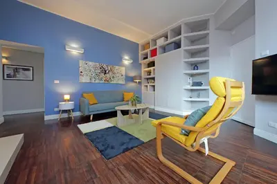 a living room with a yellow chair and a couch at 4BNB - Armot House Vatican Apartment in Rome