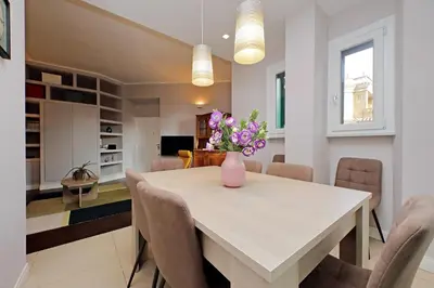 a dining room with a table with a vase of flowers on it at 4BNB - Armot House Vatican Apartment in Rome