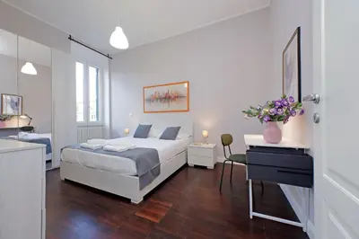 a white bedroom with a bed and a desk at 4BNB - Armot House Vatican Apartment in Rome
