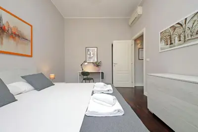 a white bedroom with a large bed and a desk at 4BNB - Armot House Vatican Apartment in Rome