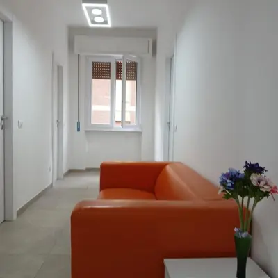 a living room with an orange couch and a window at Grand Nomentana Roma in Rome