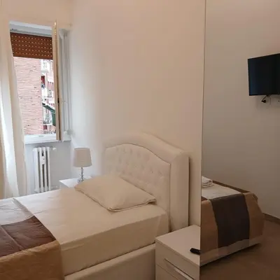 a white bedroom with a bed and a window at Grand Nomentana Roma in Rome