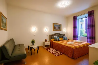 a bedroom with a bed and a chair and a window at NEXUS Palace in Rome