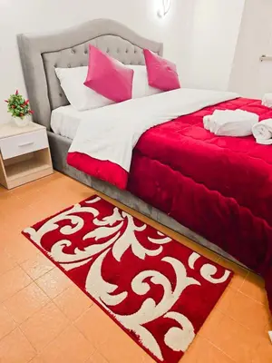 a red and white bed with a red and white rug at NEXUS Palace in Rome