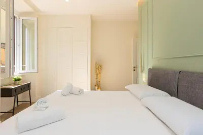 a bedroom with a large white bed and a window at La dolce vita Cavour in Rome