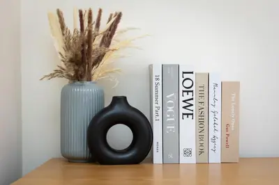 a vase sitting on a table next to some books at La dolce vita Cavour in Rome