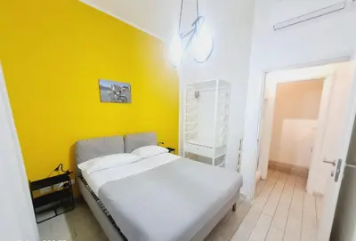 a bedroom with a white bed and a yellow wall at Bed&BikeRome ANGELICO in Rome