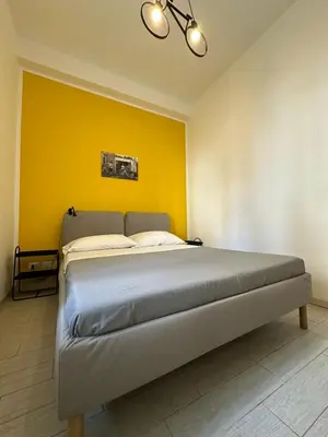 a bed in a room with a yellow wall at Bed&BikeRome ANGELICO in Rome
