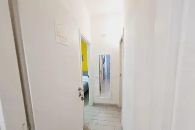 a hallway with two doors and a mirror at Bed&BikeRome ANGELICO in Rome