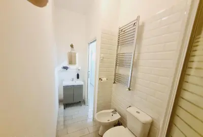 a white bathroom with a toilet and a sink at Bed&BikeRome ANGELICO in Rome