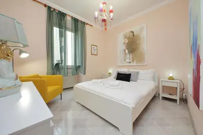 a bedroom with a white bed and a yellow chair at Vatican Museums Art Apartment in Rome