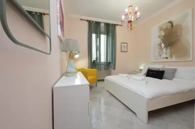 a living room with a white bed and a yellow couch at Vatican Museums Art Apartment in Rome