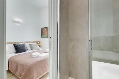 a bedroom with a bed and a glass shower at Casa di Zio Colosseo in Rome