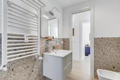 a white bathroom with a sink and a mirror at Casa di Zio Colosseo in Rome