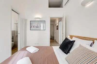 a bedroom with a large white bed with black pillows at Casa di Zio Colosseo in Rome