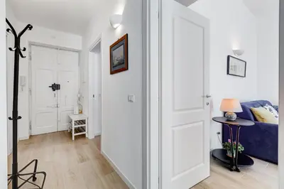 a hallway with a blue couch in a white apartment at Casa di Zio Colosseo in Rome