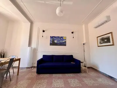 a living room with a blue couch and a table at The Place Strozzi in Rome