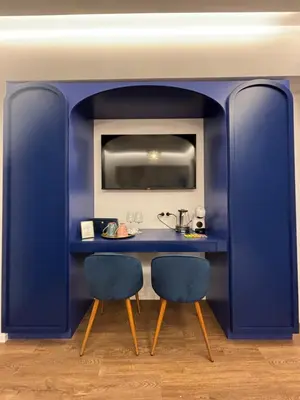 a blue kitchen with two chairs and a table at Atrium Regal Room in Rome