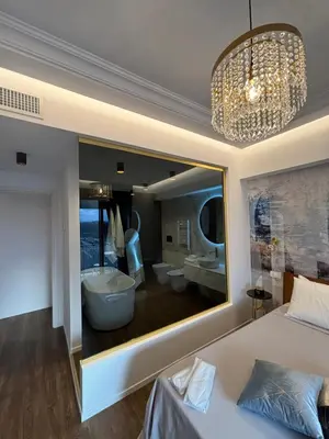 a bedroom with a large window with a tub and a bathroom at Atrium Regal Room in Rome