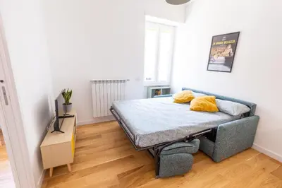 a bedroom with a bed with yellow pillows on it at L'Appartamentino a San Giovanni in Rome