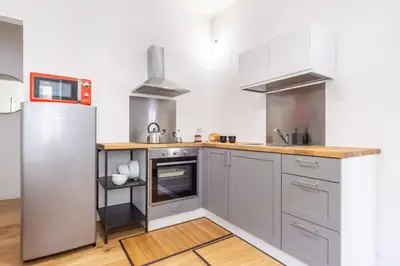 a kitchen with gray cabinets and a white refrigerator at L'Appartamentino a San Giovanni in Rome