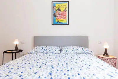 a bedroom with a bed with a poster on the wall at L'Appartamentino a San Giovanni in Rome