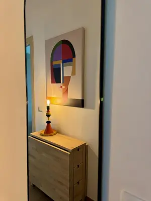 a mirror in a room with a dresser and a painting at Grazioso appartamento Tiburtina - 3 bedrooms in Rome