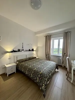 a bedroom with a bed and a table and a window at Grazioso appartamento Tiburtina - 3 bedrooms in Rome