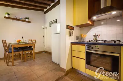a kitchen with a stove and a table with a dining room at Green Apartments Rome in Rome