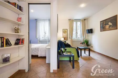 a living room with a green chair and a bed at Green Apartments Rome in Rome