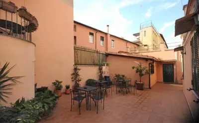 a patio with tables and chairs in a courtyard at Green Apartments Rome in Rome