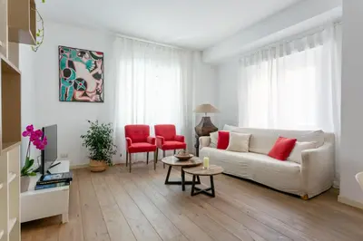a living room with a white couch and red chairs at Vatican Stay in Rome