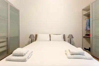 a bedroom with a large white bed with two towels at Vatican Stay in Rome