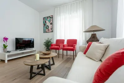 a living room with a white couch and red chairs at Vatican Stay in Rome