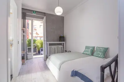 a bedroom with a bed and a door to a balcony at kathy Home Rome Suite in Rome