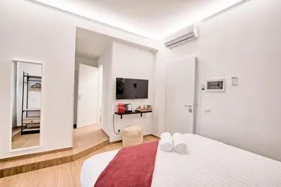 a white room with a bed and a tv at Caesar's quarters - private rooms in Rome in Rome