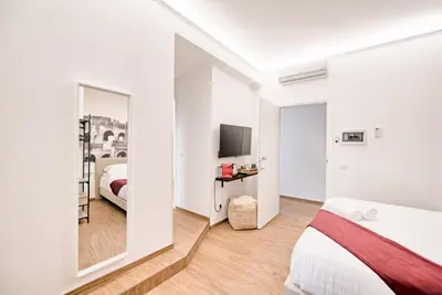 a bedroom with a bed and a mirror and a tv at Caesar's quarters - private rooms in Rome in Rome