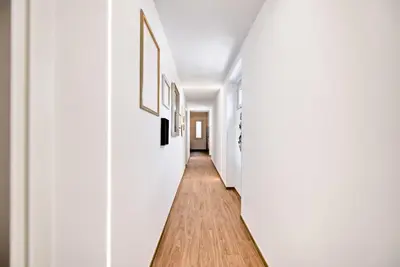 a hallway with white walls and a wooden floor at Caesar's quarters - private rooms in Rome in Rome