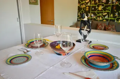 a table with three wine glasses and plates on it at Splendido attico a Roma in Rome