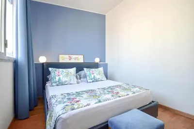 a bedroom with a bed with a blue wall at Splendido attico a Roma in Rome