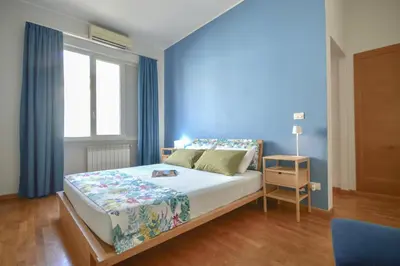 a bedroom with a large bed with a blue wall at Splendido attico a Roma in Rome