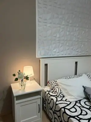 a bedroom with a bed and a vase with flowers on a night stand at Caroline Home in Rome