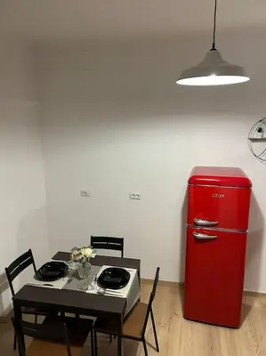 a table and a red refrigerator in a room at Caroline Home in Rome