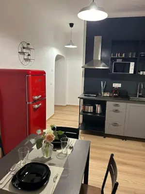a kitchen with a table and a red refrigerator at Caroline Home in Rome