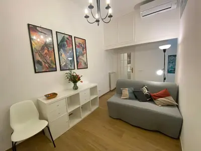 a white bedroom with a bed and a chair at Le mongolfiere in Rome